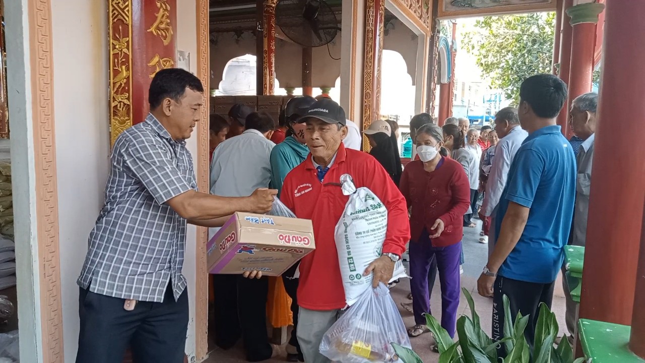Hội viên Hội Chữ thập đỏ xã Khánh Bình hỗ trợ người già yếu đến nhận quà 